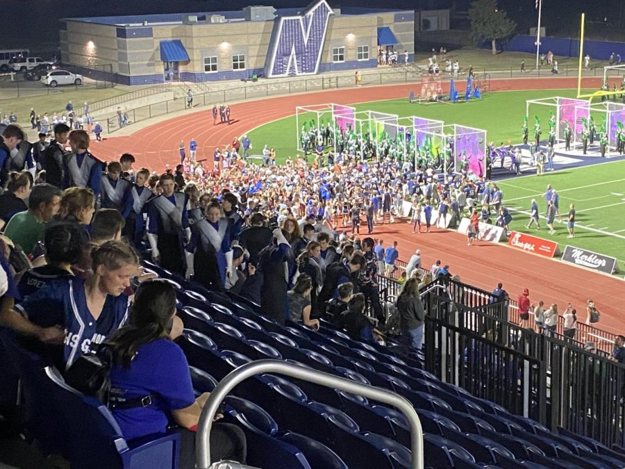 The Edmond North student section rushes the field after the win. (photo credit Ethan Unsell)