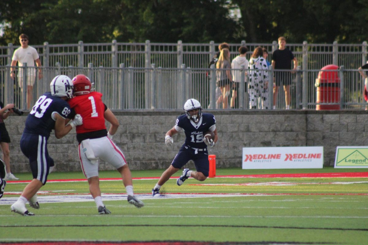 Number 19 avoiding Farmington Cardinals defensive line with the ball.