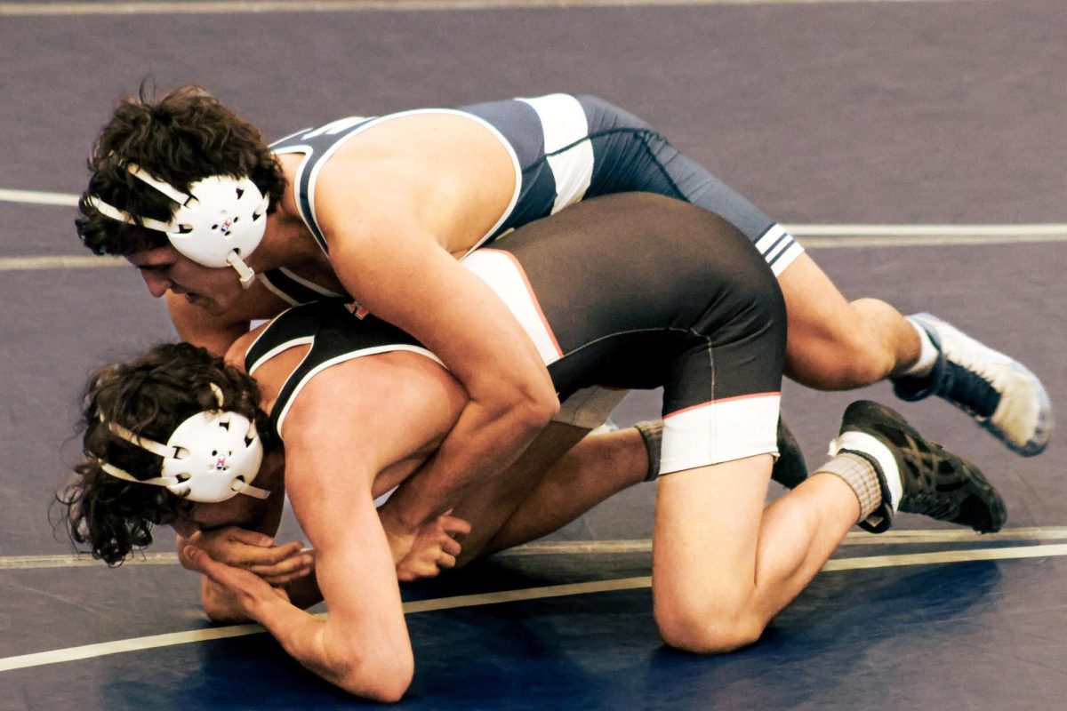 Senior Levi White grabs his opponent's wrist to turn him on to his back. After running two of his tilts, White would eventually get the fall.